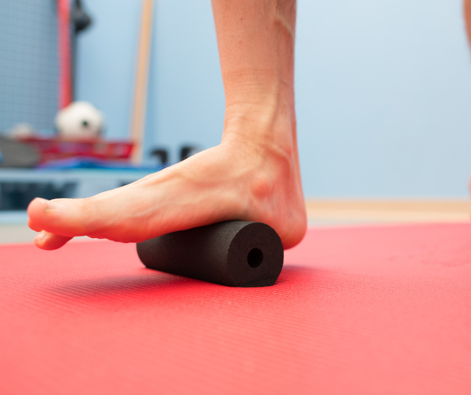 Bare right foot with foam roller under arch area