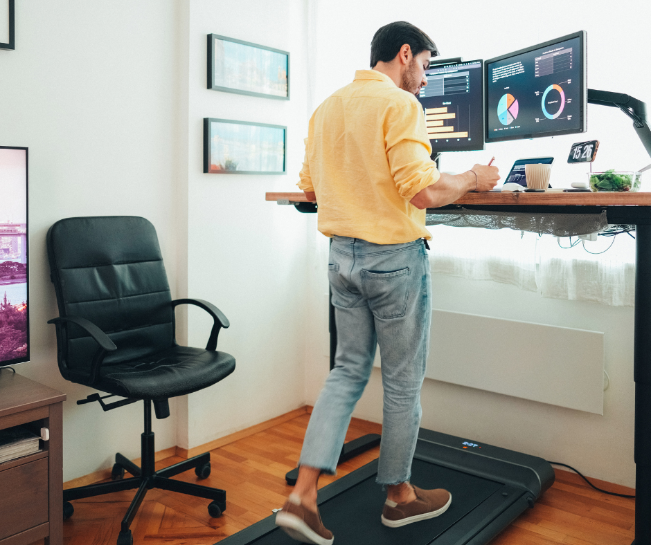 person working at a desk walking on a treadmill