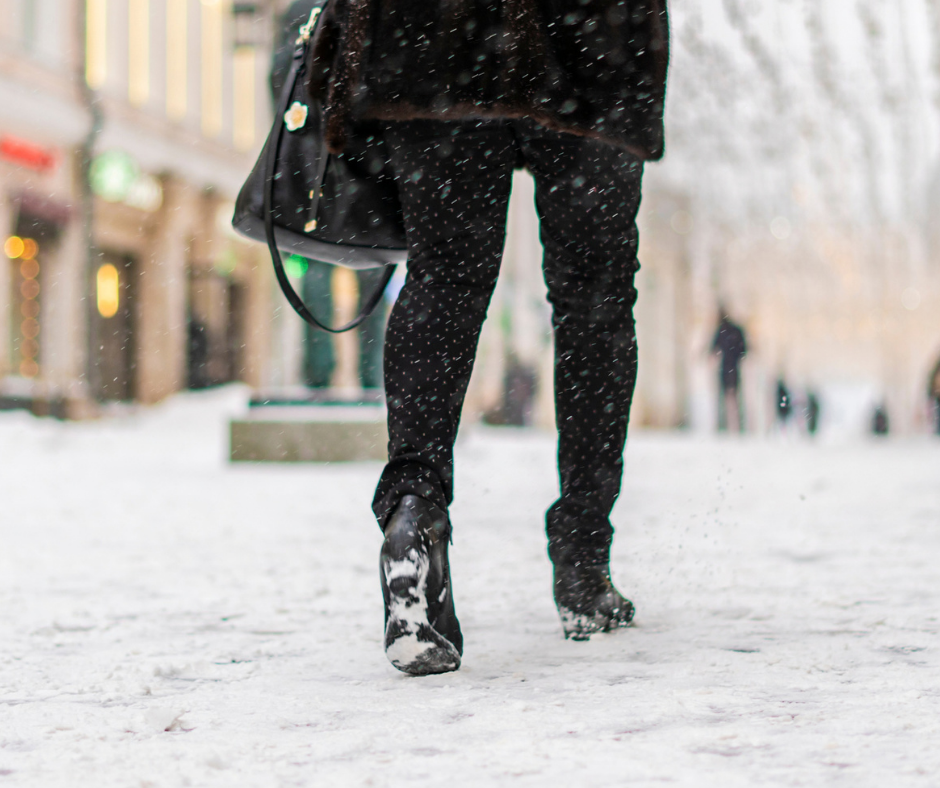 woman walking in the snow in a city